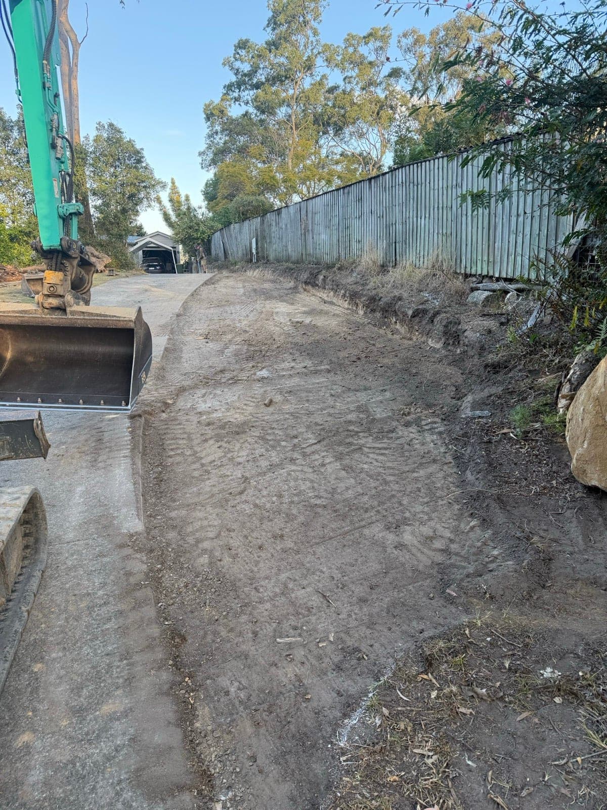 5.5 tonne excavator shaping and edging a residential driveway along a boundary fence (Southeast Queensland, previous work)