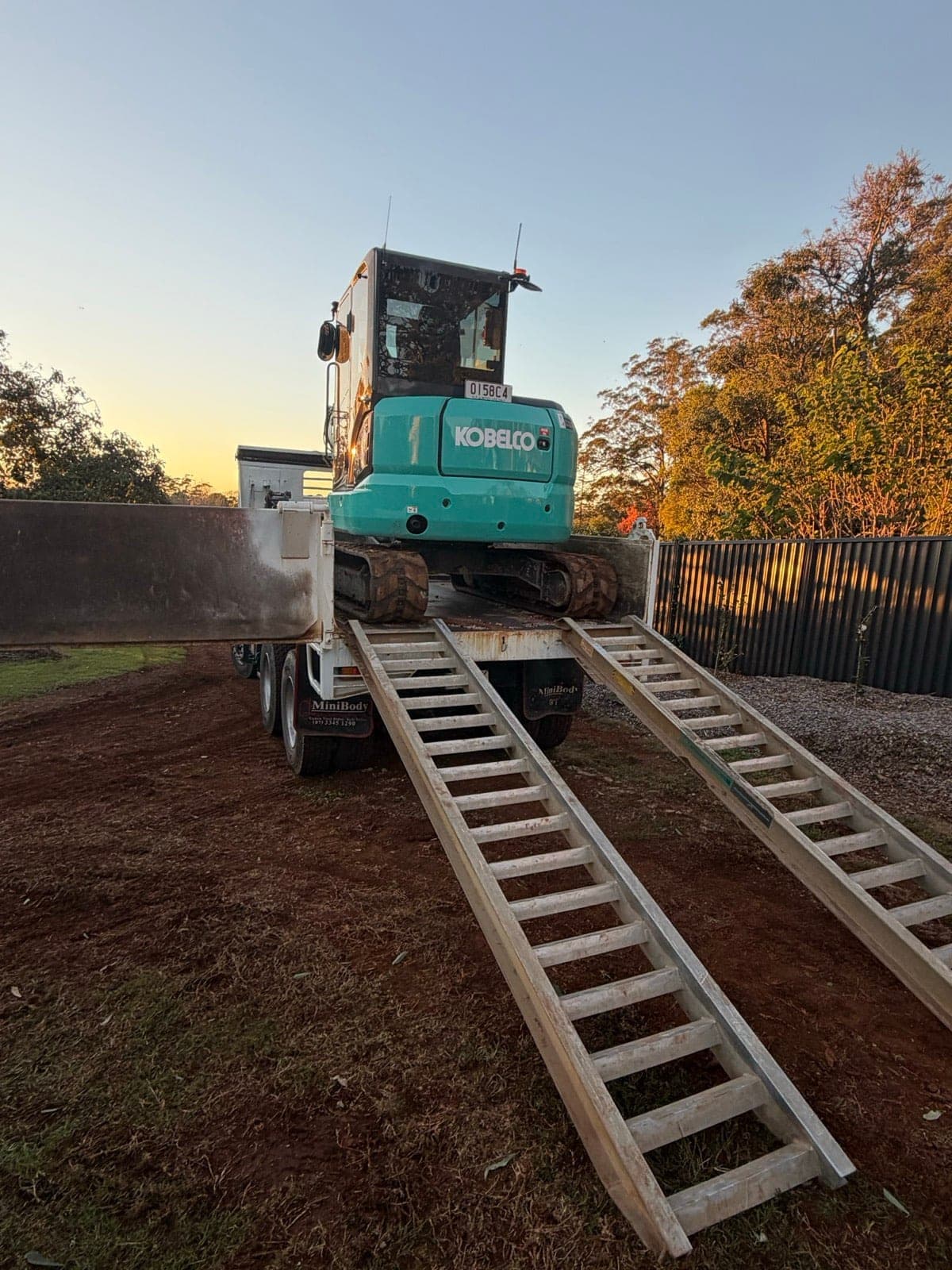 Kobelco excavator loading onto the tipper