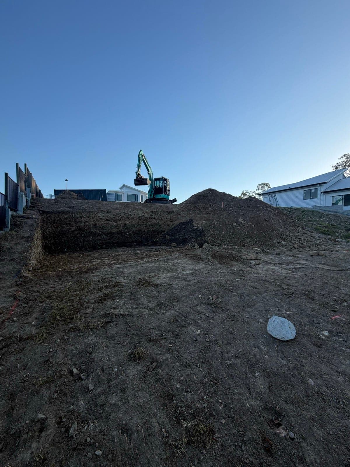 5.5 tonne excavator cutting a level house pad into a sloping block in a new estate (Southeast Queensland, previous work)